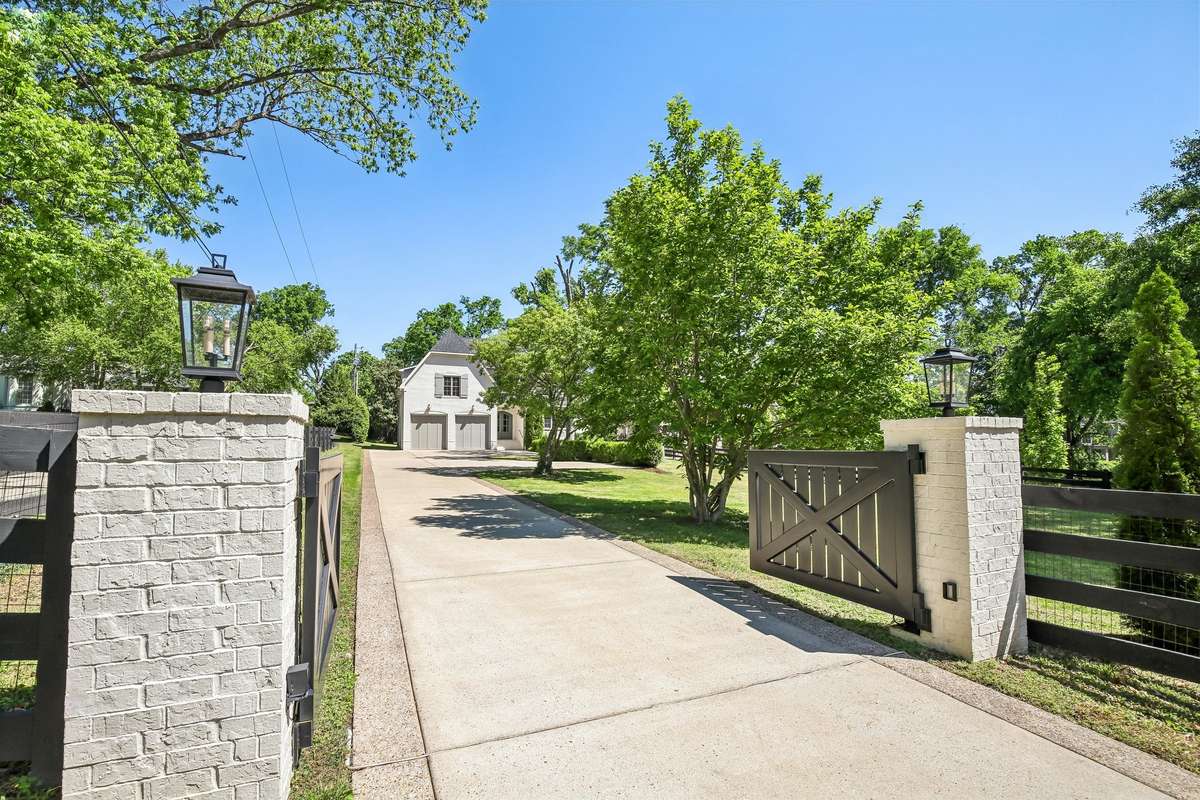 Gated entry with stone columns and private drive.