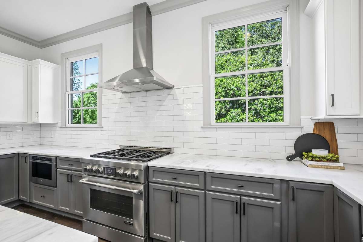JennAir gas range with vent hood and subway tile backsplash