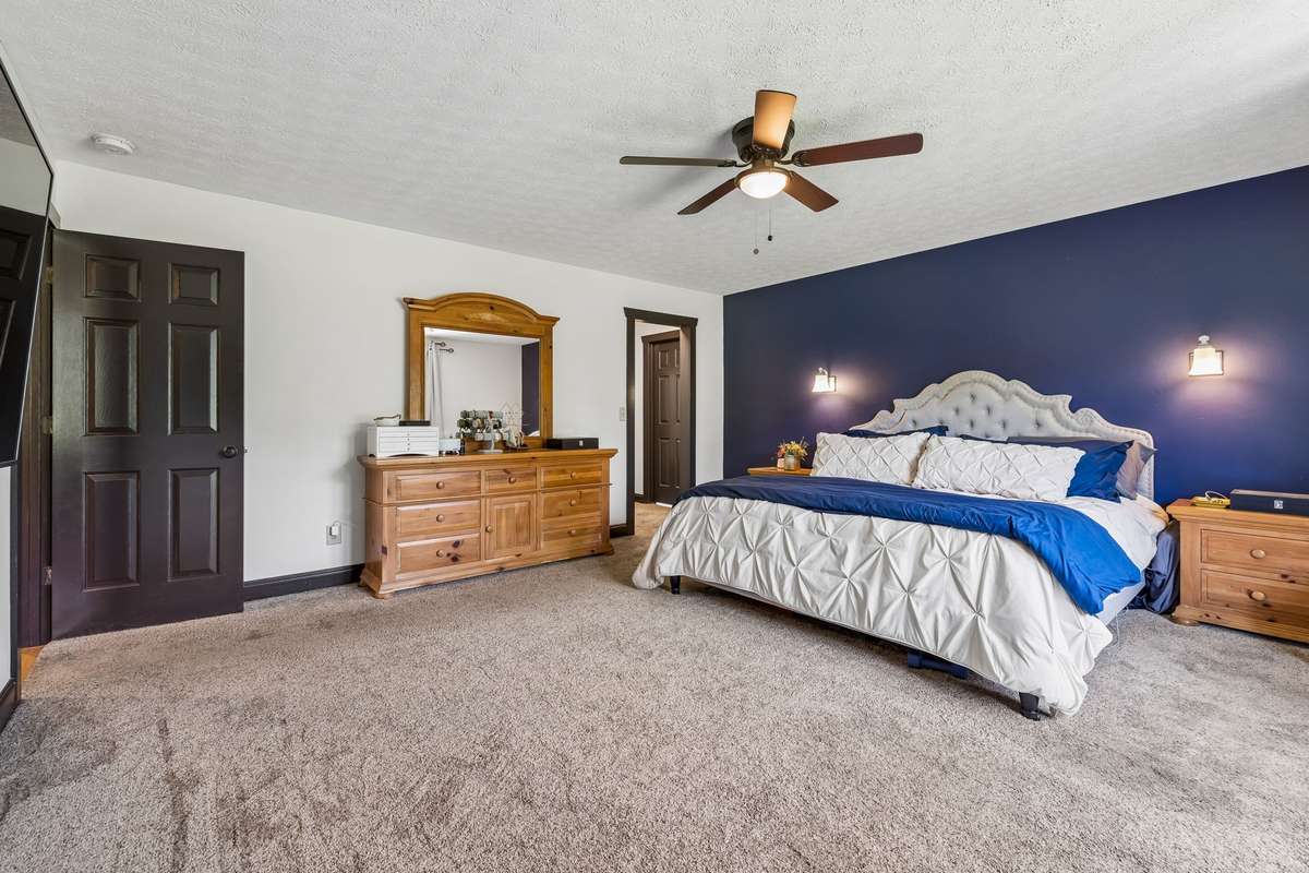 Alternate view of the primary bedroom featuring large windows for natural light and a comfortable, relaxing atmosphere.