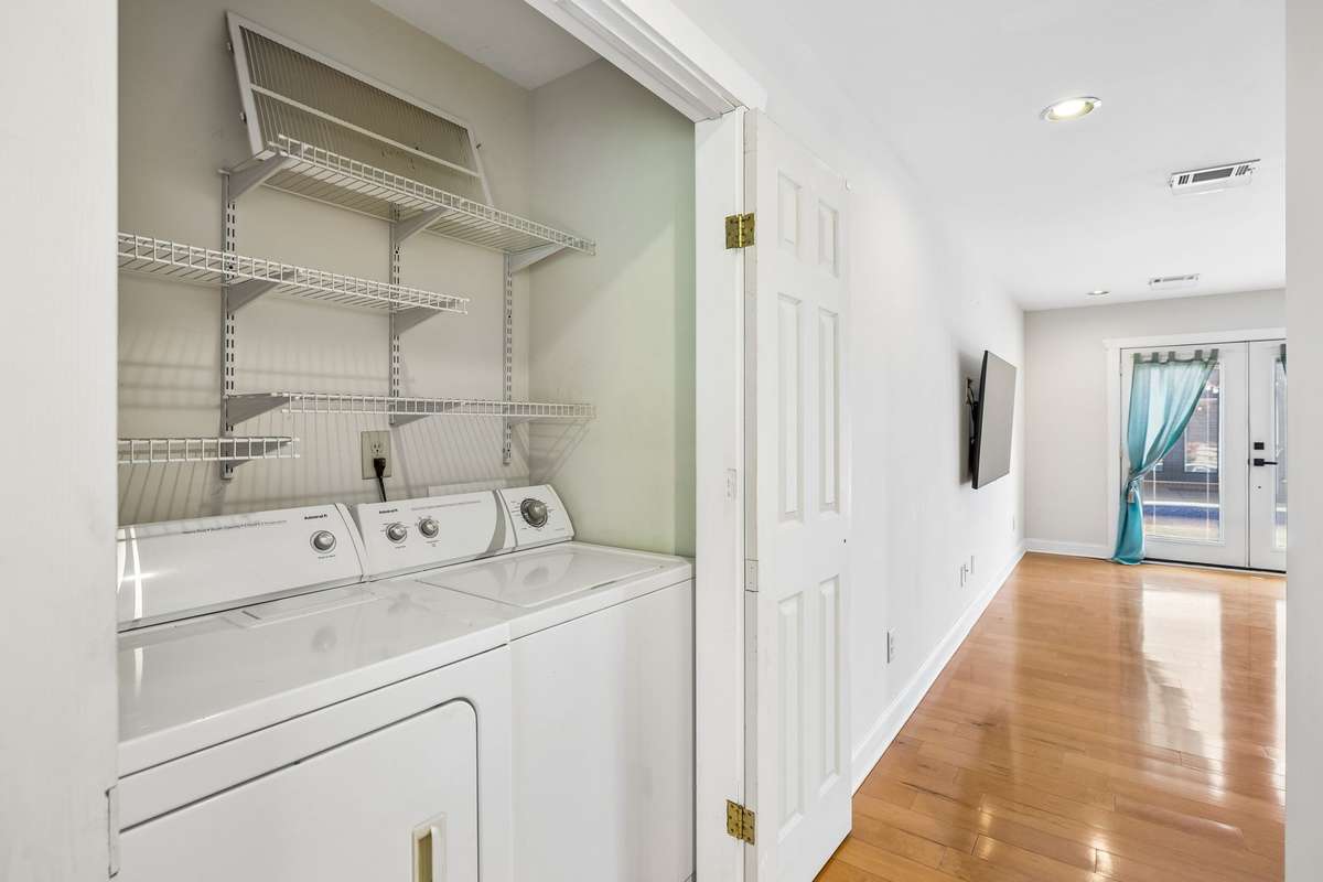 Guest house. Convenient in-unit laundry closet with washer/dryer hookups and built-in shelving for added storage and organization.