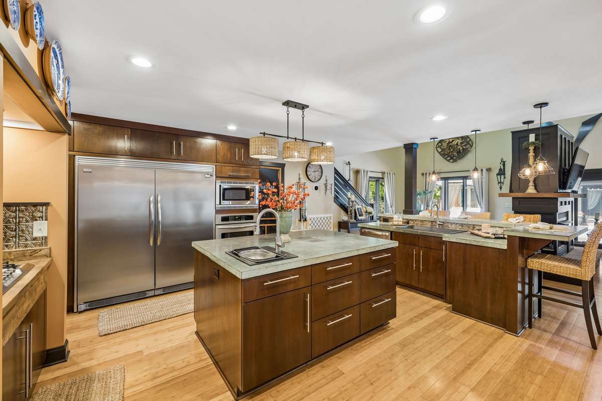 Open-concept kitchen with expansive island and bar seating, modern fixtures, and seamless flow into the dining area. Bright, airy feel with recessed lighting, hardwood floors, and stylish finishes throughout.