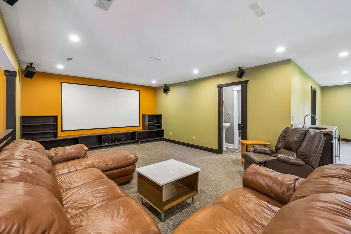 Media room setup with projector screen and surround sound, creating the perfect home theater experience.
