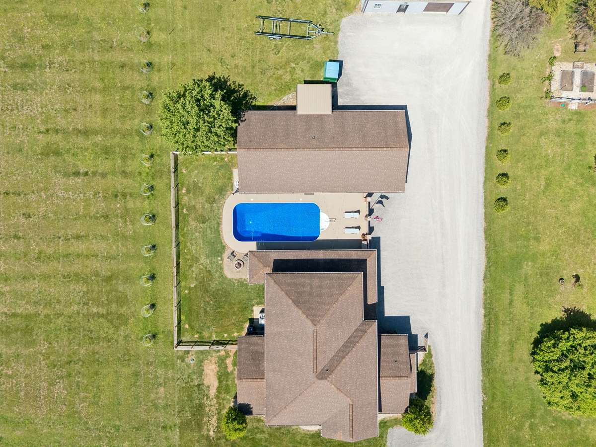Top-down aerial view clearly outlining the pool area, detached structures, and layout of the home on the property.