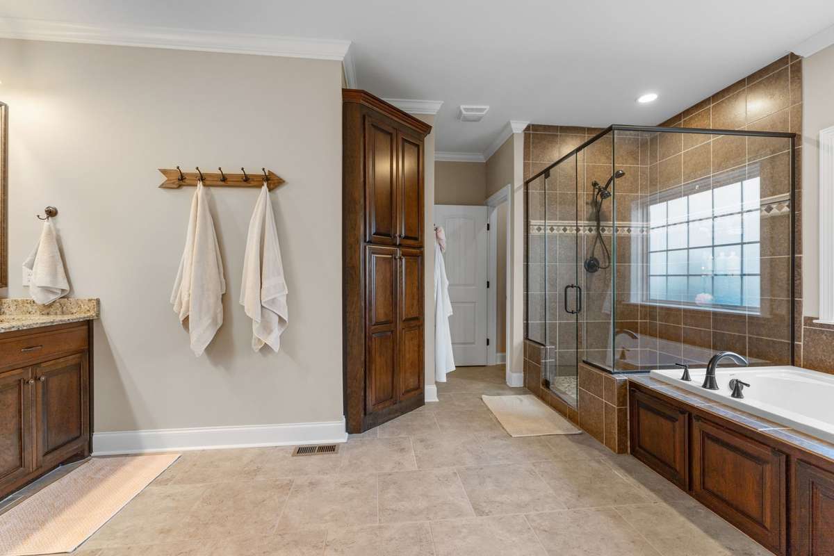 Master bedroom leads into the ensuite master bath with his and her walk-in closets on either side of the entryway.