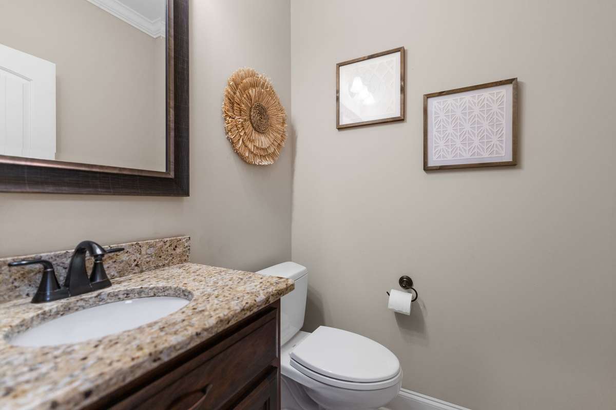 Heading to the stairs from the living room, there is a half bath just off the foyer.