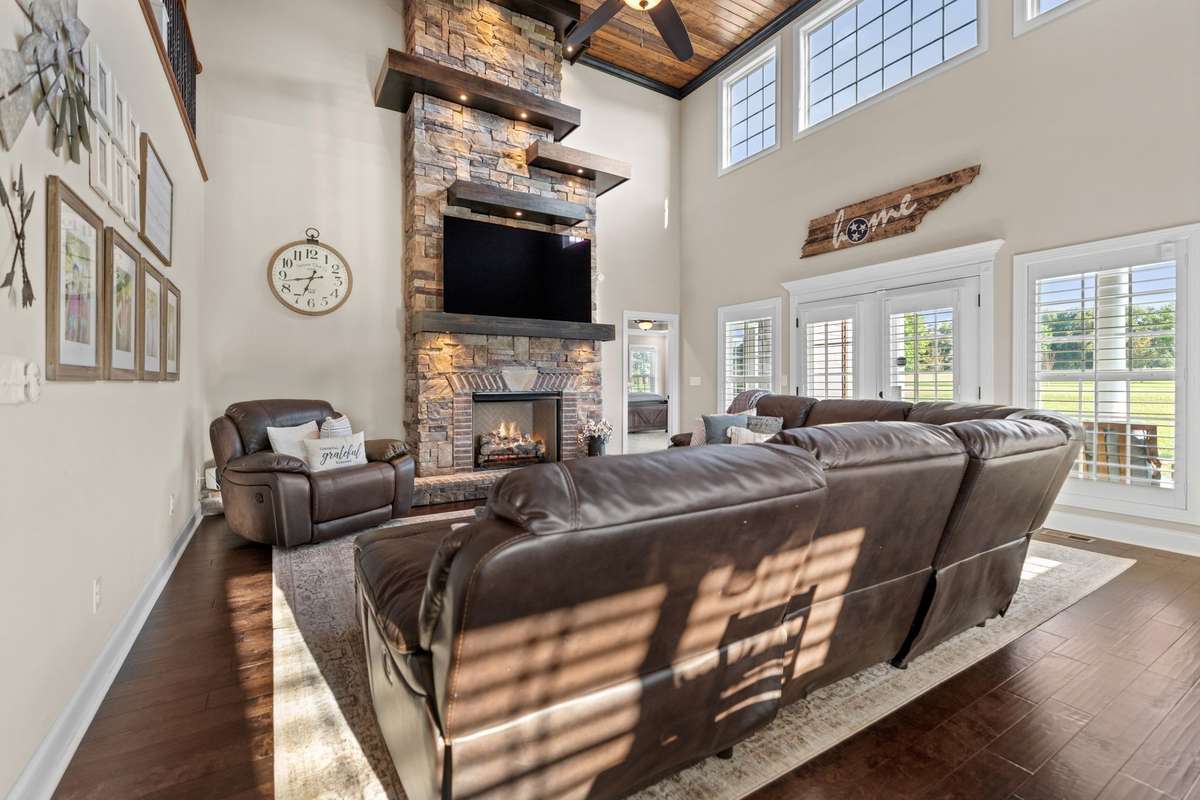 Enjoy the two story rock fireplace with custom lit shelving.