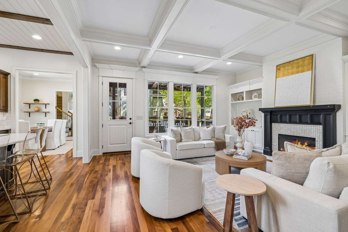 The space flows beautifully into the living room, where coffered ceilings, a gas fireplace, custom built-ins, and abundant natural light create a warm and welcoming atmosphere.