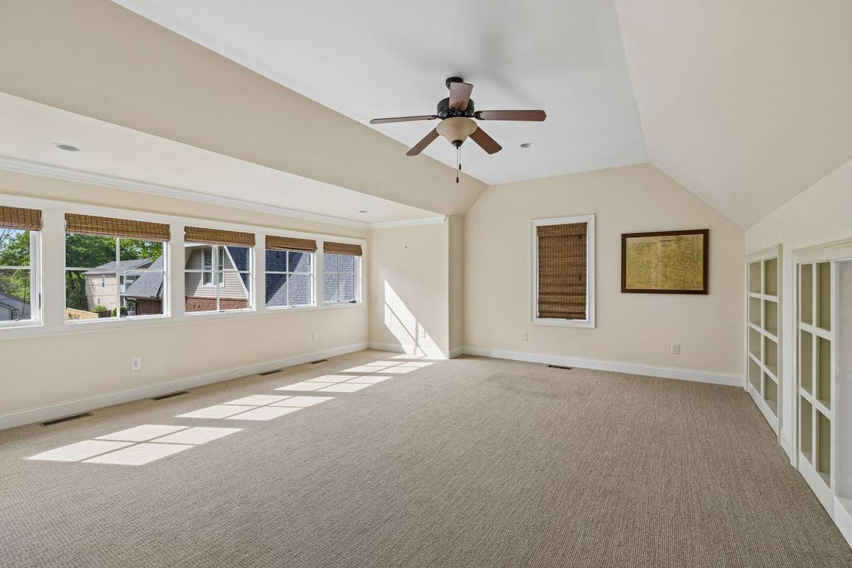 A private staircase leads to a second-level bonus or media room with a full bath—perfect as a secluded guest suite or flexible living space.