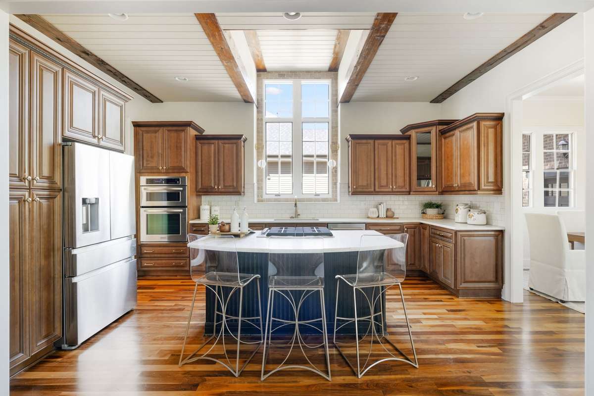 The open-concept kitchen is truly the heart of the home, featuring soaring ceilings and expansive windows that flood the space with light.