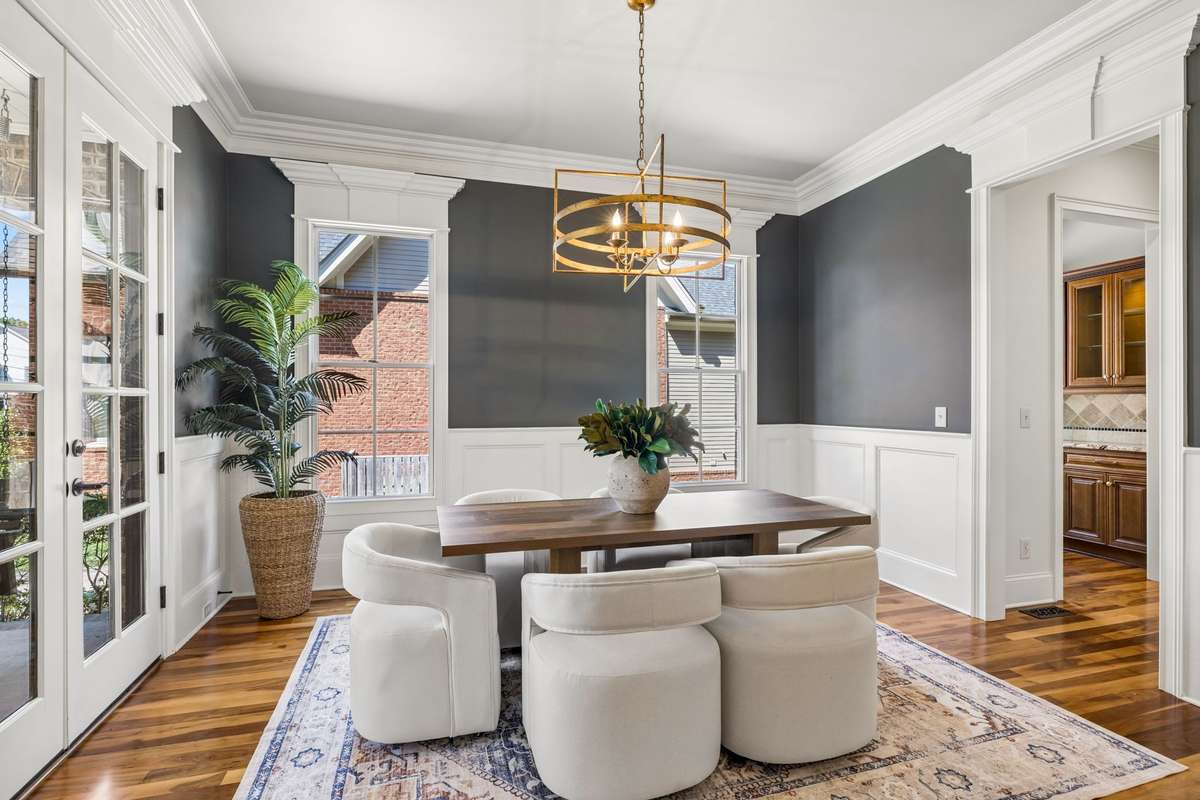 Just off the foyer, a formal dining room offers seamless access to a pantry and a versatile dry bar or workspace, making entertaining effortless.
