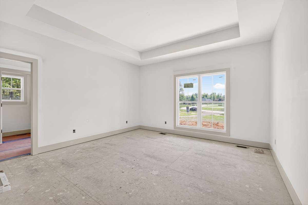 Primary bedroom with a trey ceiling and no carpet. The LVP flooring will continue throughout the bedrooms.