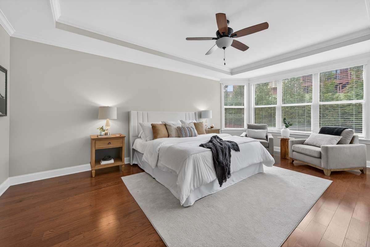 The primary light filled bedroom is of a large scale, with trey ceilings, and the most beautiful bay windows.