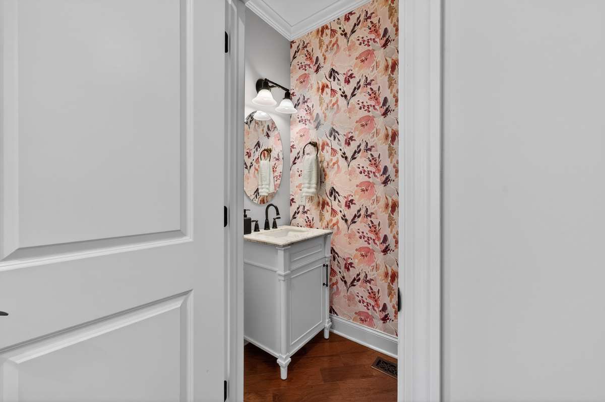 Beautifully appointed powder bath with custom wallpaper and curated finishes—bringing personality and polish to the main level.