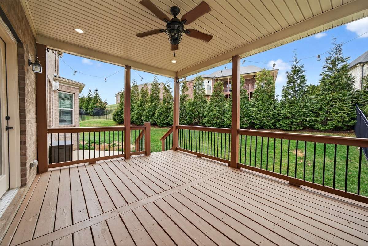 The large outdoor deck overlooks the backyard to the left and the pool/hot tub to the right.