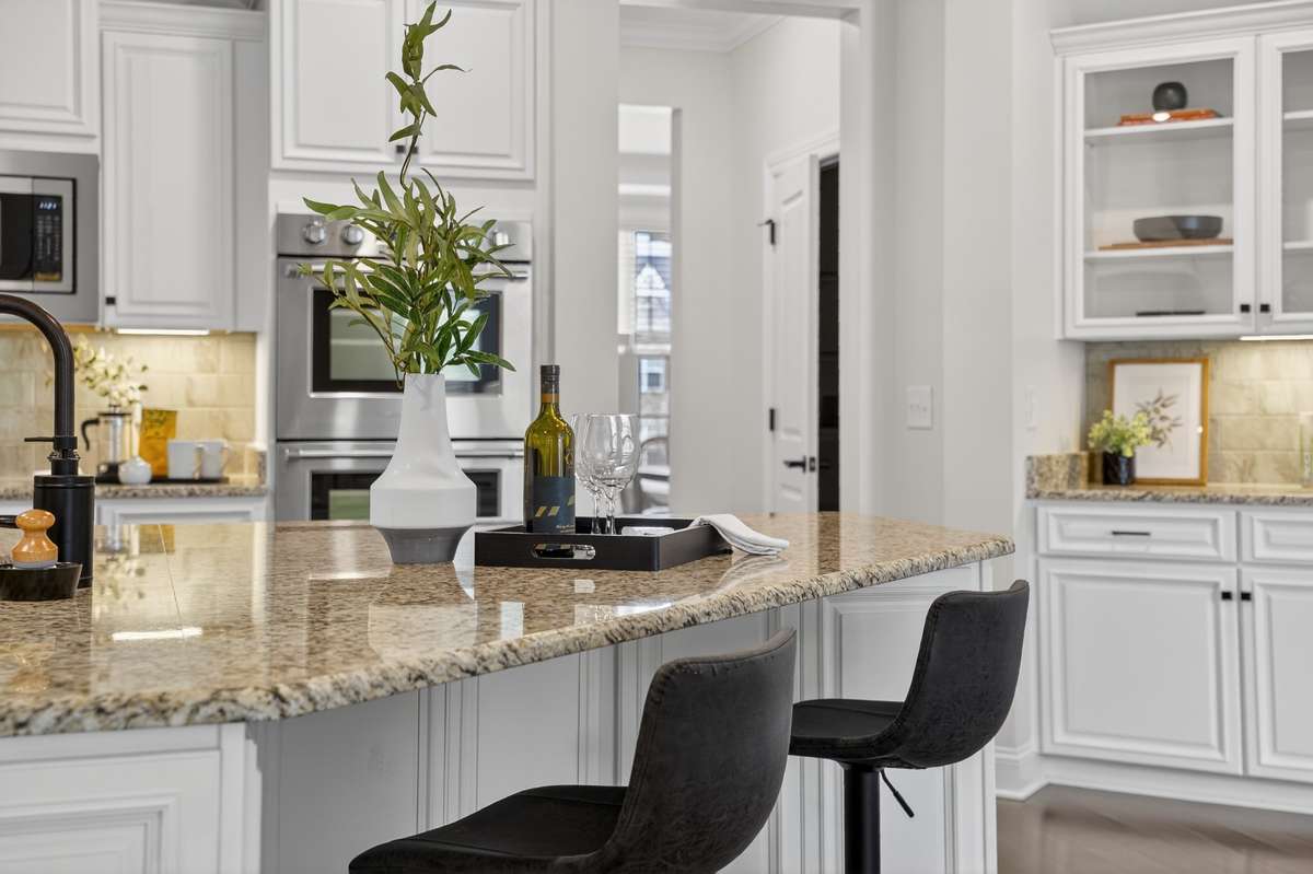 A large island centers the space that flows into the living room and informal dining creating a beautiful flow for entertaining guests.