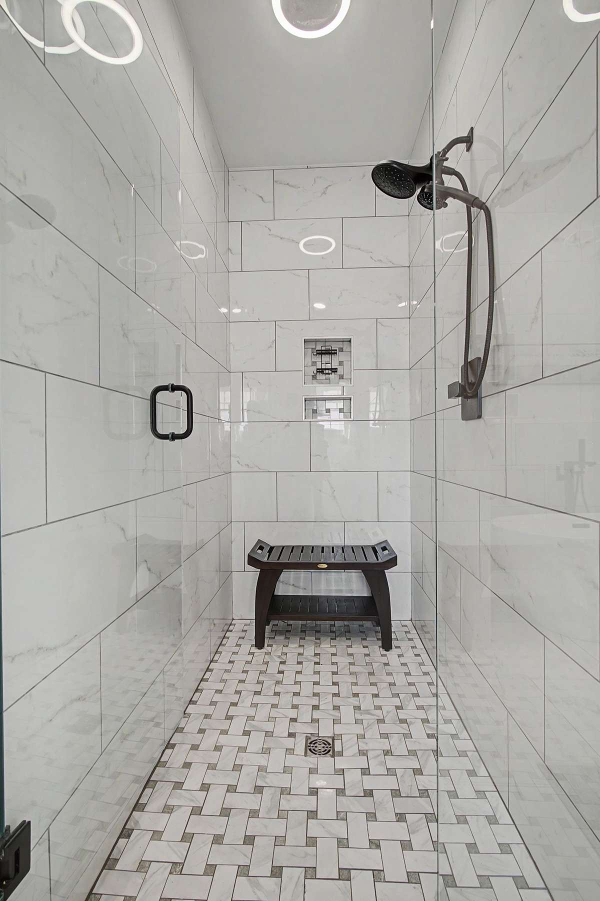 Walk-in, tile shower with glass door in the primary bath.