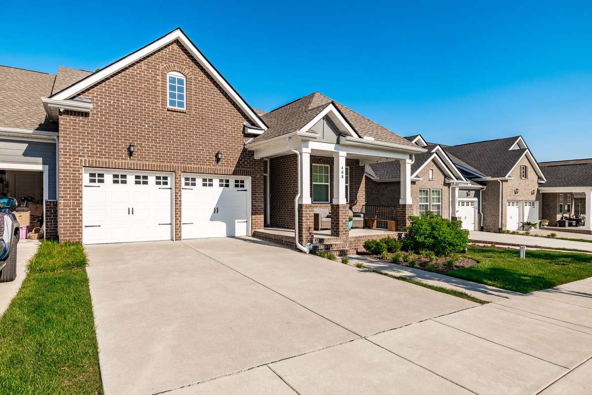 2 car garage and a front porch that is perfect for sitting and greeting neighbors