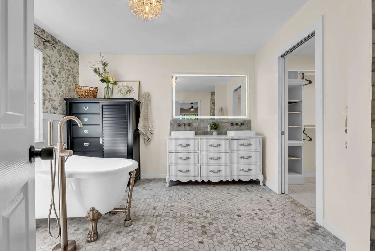 Fully remodeled in 2022, featuring a clawfoot soaking tub, walk-in shower, and double sink vanity, pocket door to walk-in closet.