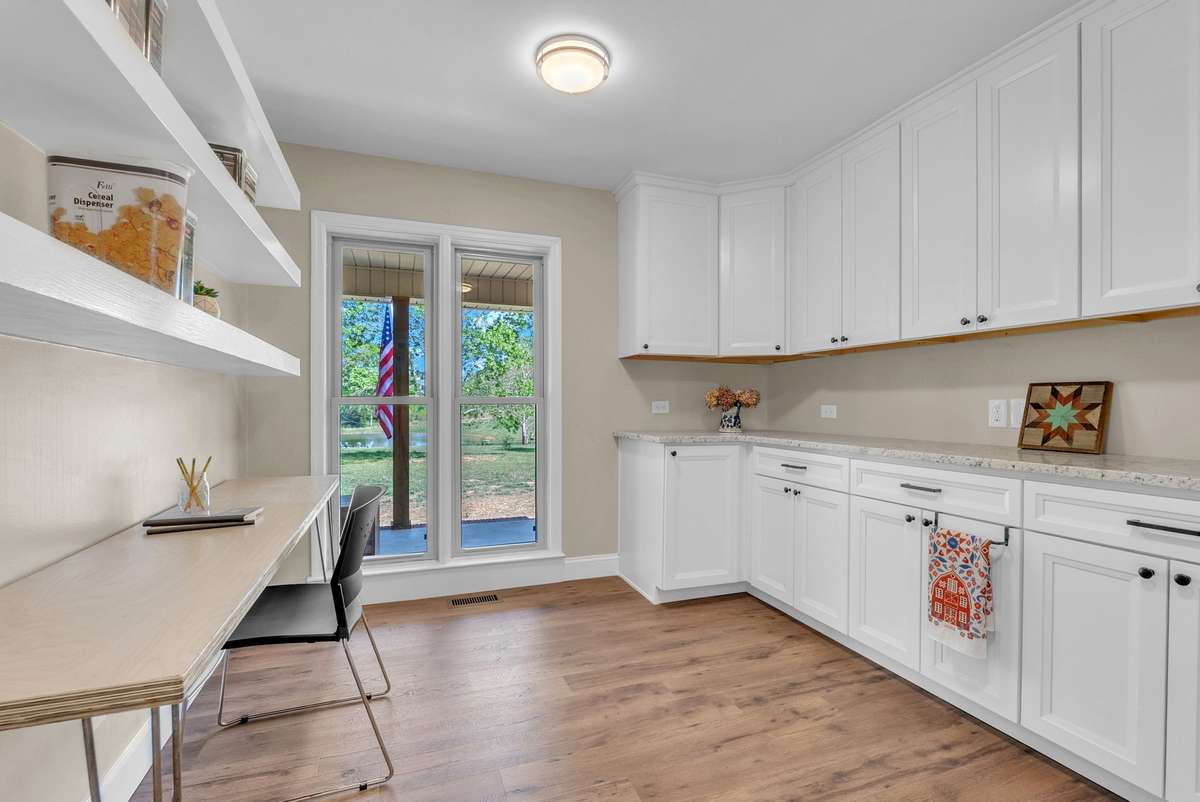 Adjacent to the kitchen. Built-in cabinets with a granite countertop that matches the kitchen. Floating shelves on one wall with an area for an office/study desk below it.