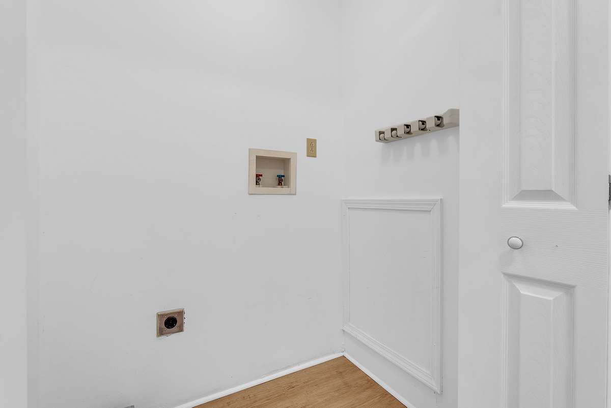 Mother-in-law apartment: Practical utility area in the mother-in-law suite with recessed water valves, electrical outlets, and coat rack hooks. Perfect for storage, laundry setup, or everyday convenience in this private attached apartment
