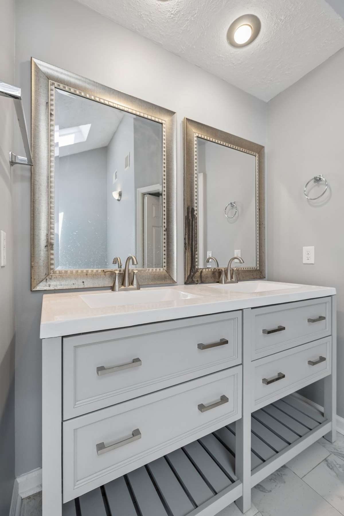 Designer mirrors hang over the double vanity.