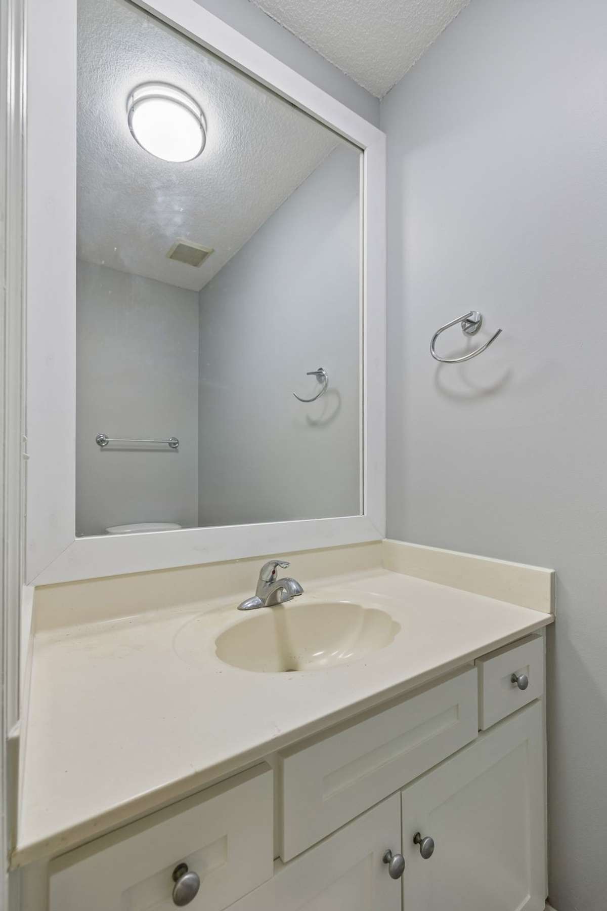 A view of the downstairs half bath. It's been freshly painted and a new overhead light was installed. It's clean and bright for family members of guests to use.