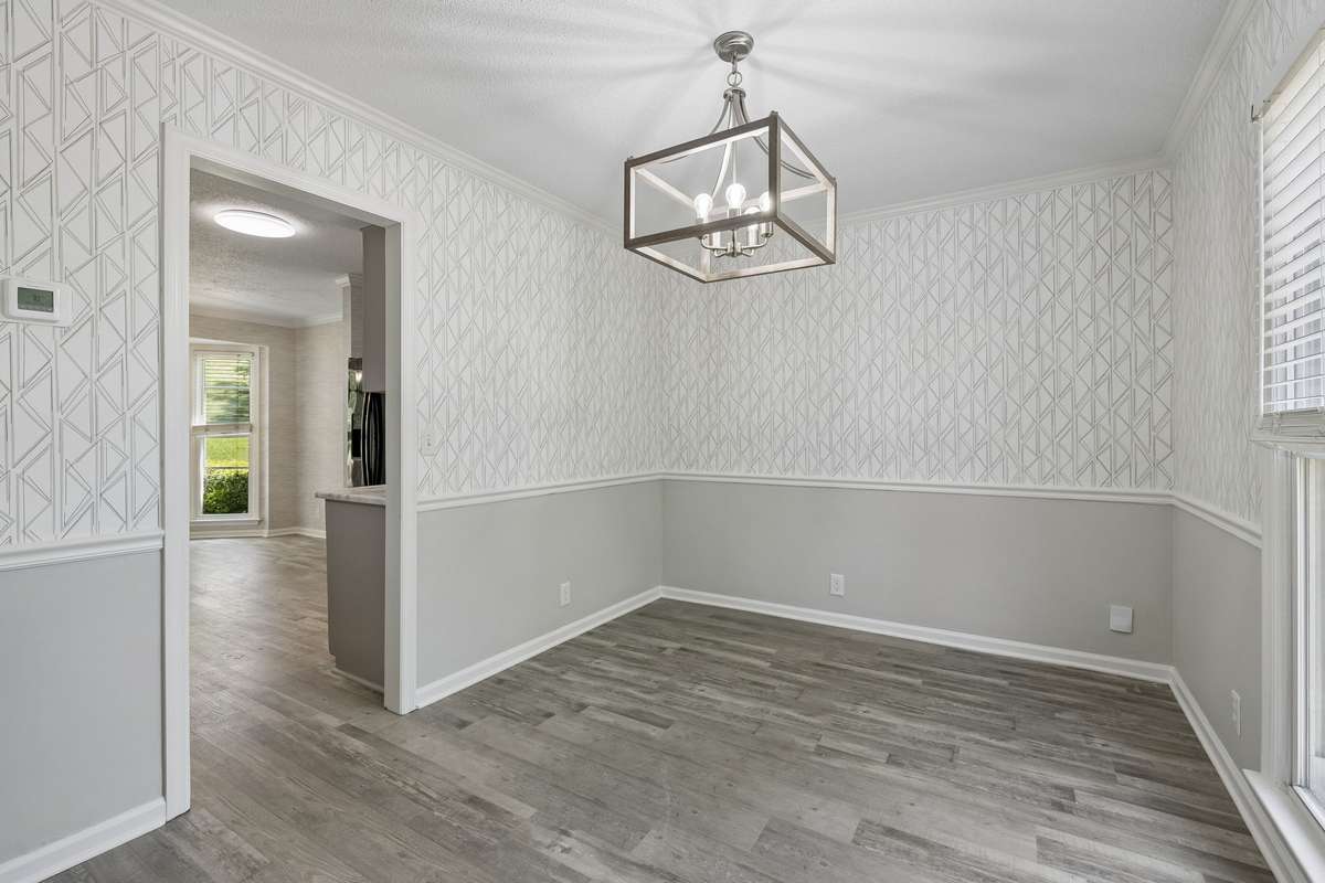 The home has a formal dining room with designer chandelier. New, contemporary wallpaper!