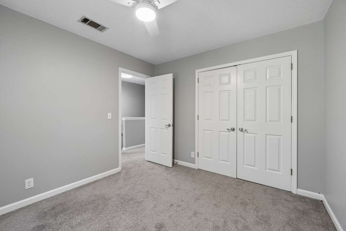 The second bedroom has a double closet. This view faces closet doors and the hallway.