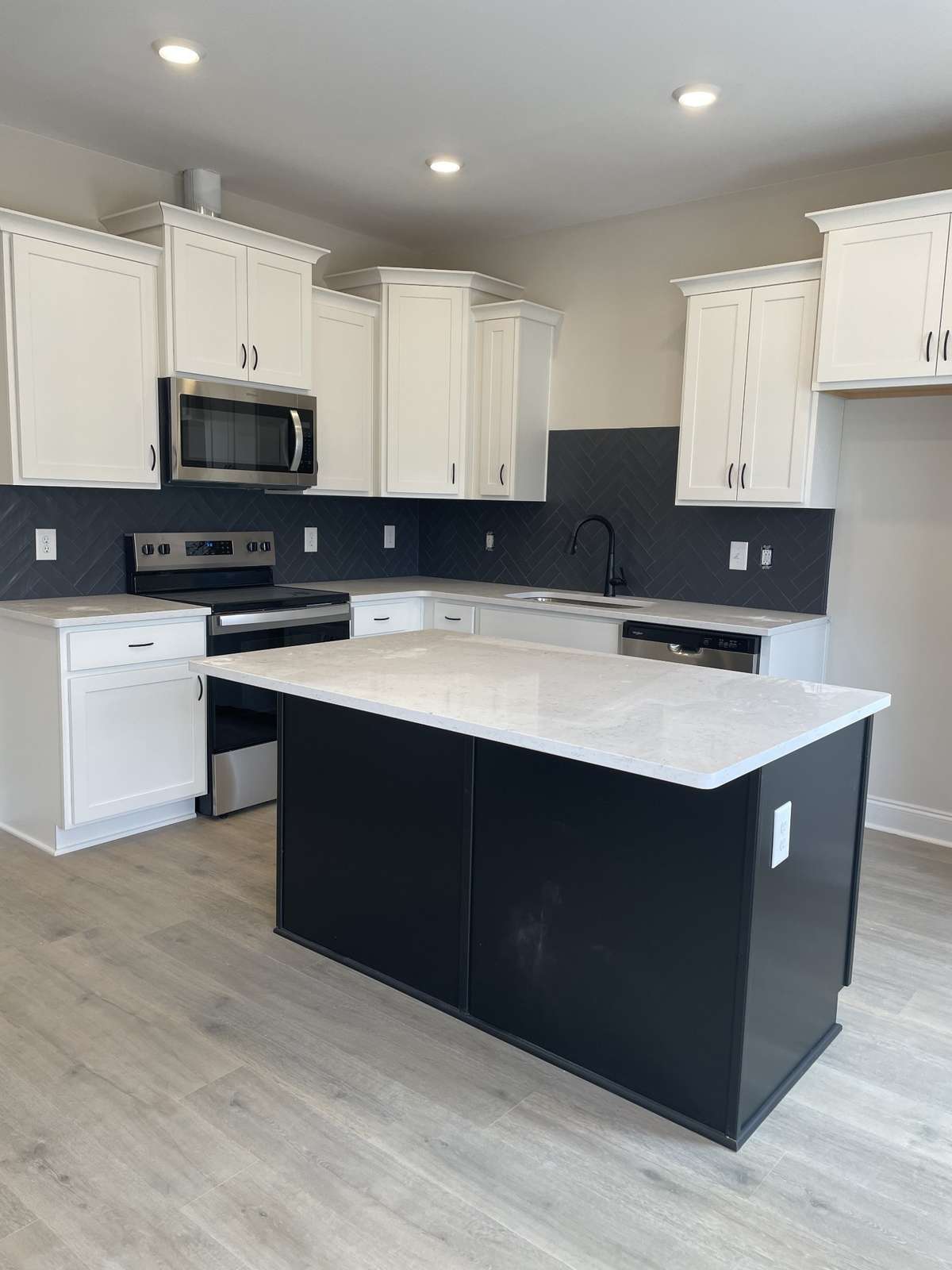 Kitchen includes island SS Stove with smooth surface cooktop, microwave and dishwasher