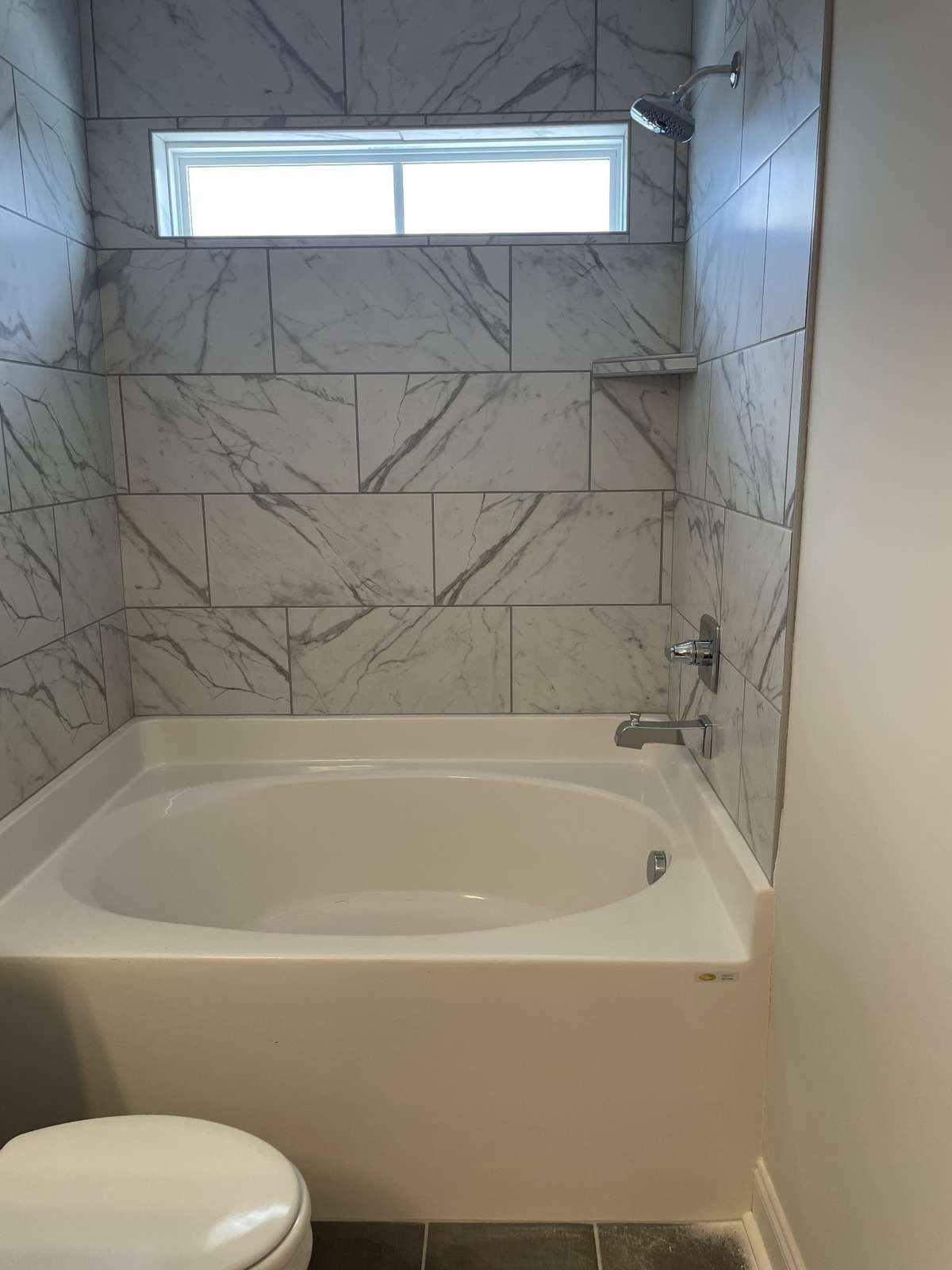 Tub Shower Combo with tile walls and floors.
