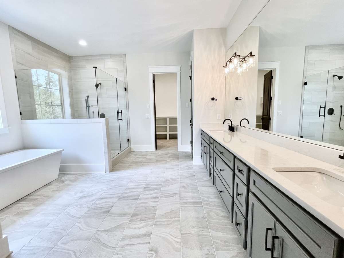The primary bathroom is a study in grand design, with its expansive layout and sleek design, creating a sense of space and serenity.