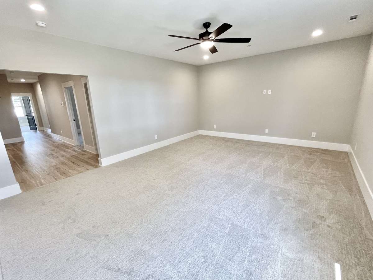 The upstairs recreational bonus room is a spacious and versatile retreat designed for fun, relaxation, and everyday living. Virtually staged photo for inspiration only & to showcase how space can be used & furnished.