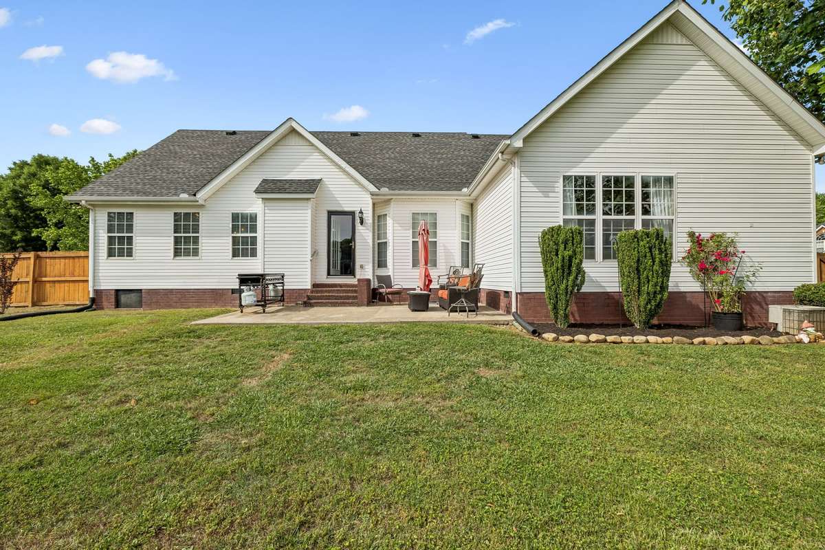 Back of home with patio and spacious yard.