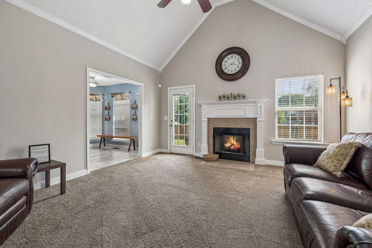 Fireplace focal point with views toward the kitchen and dining area.