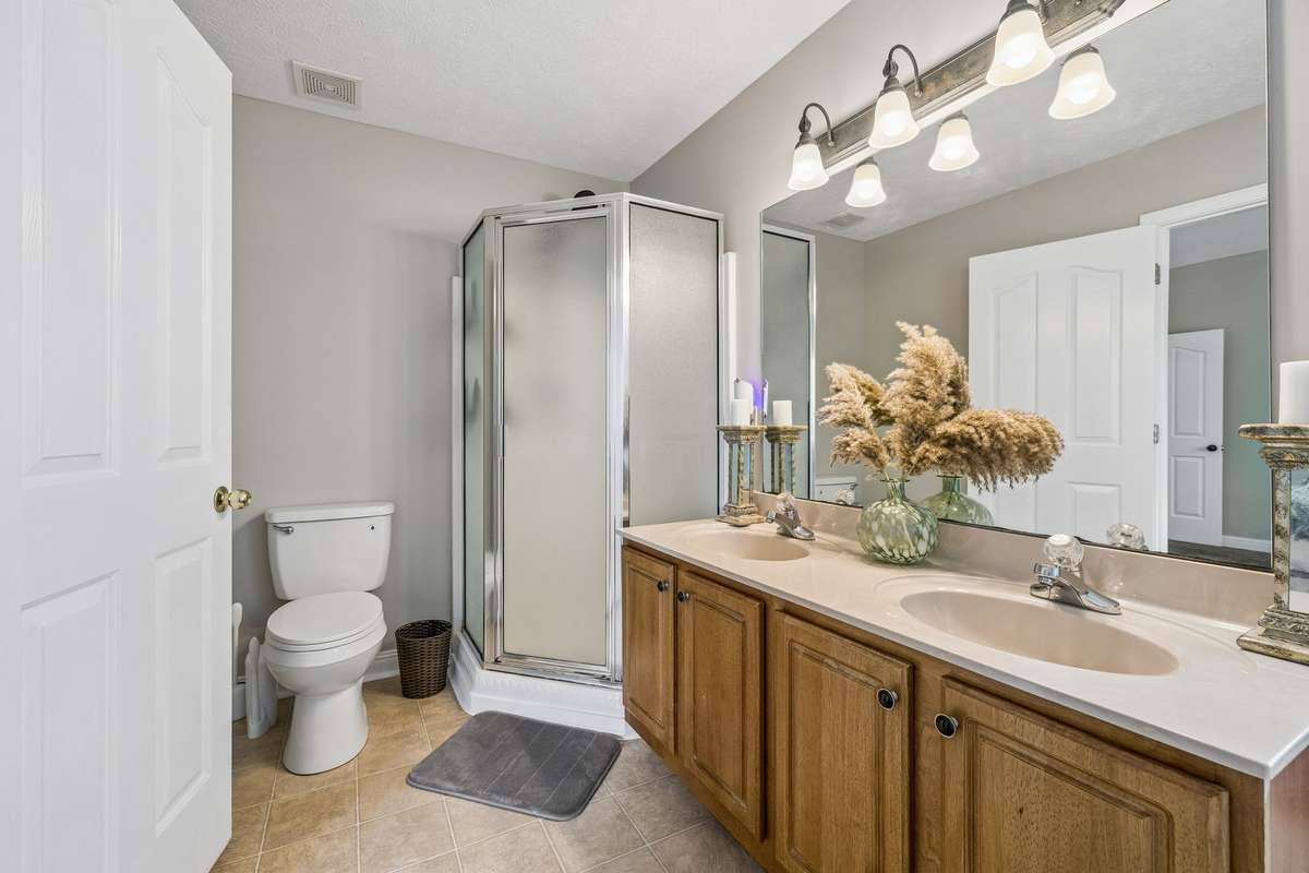 Bathroom view with double vanity and separate shower.