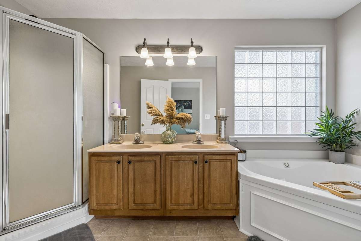 Bathroom with double vanity, soaking tub, and separate shower.