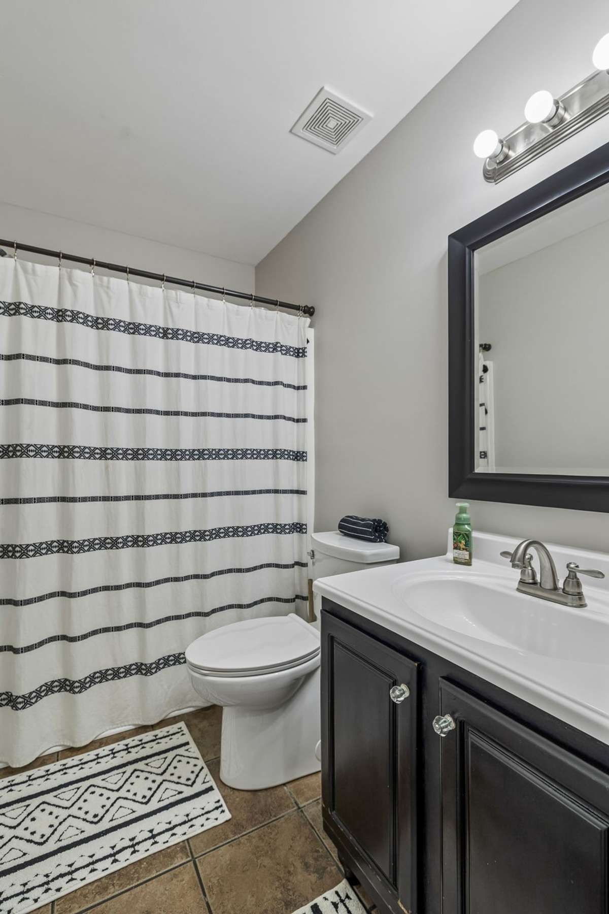 Hall full bathroom with updated vanity and tub/shower combination.