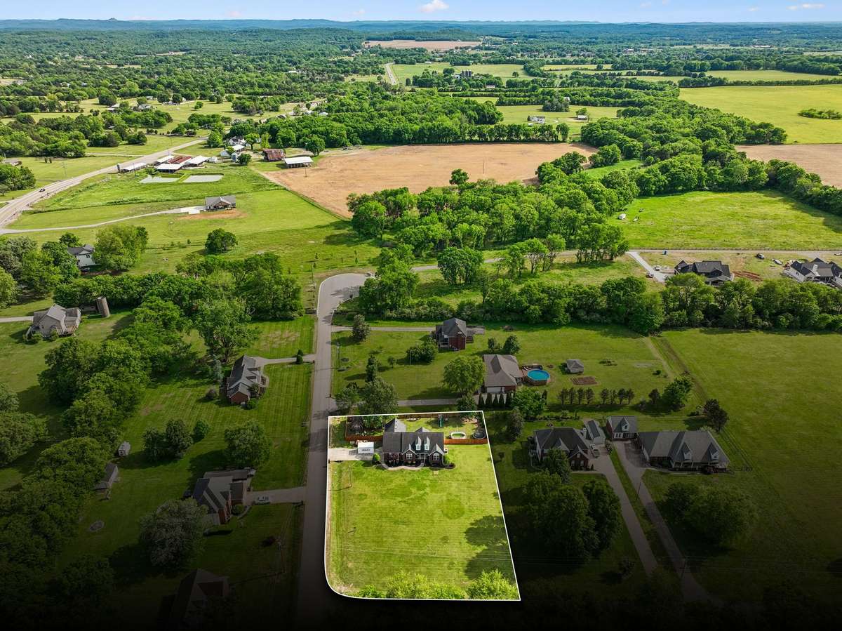 Aerial view of the home’s neighborhood and nearby open land.