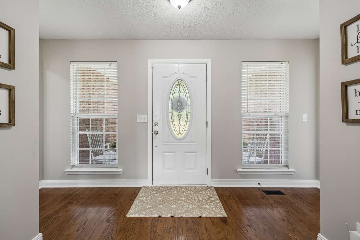 Bright foyer with hardwood flooring and natural light.