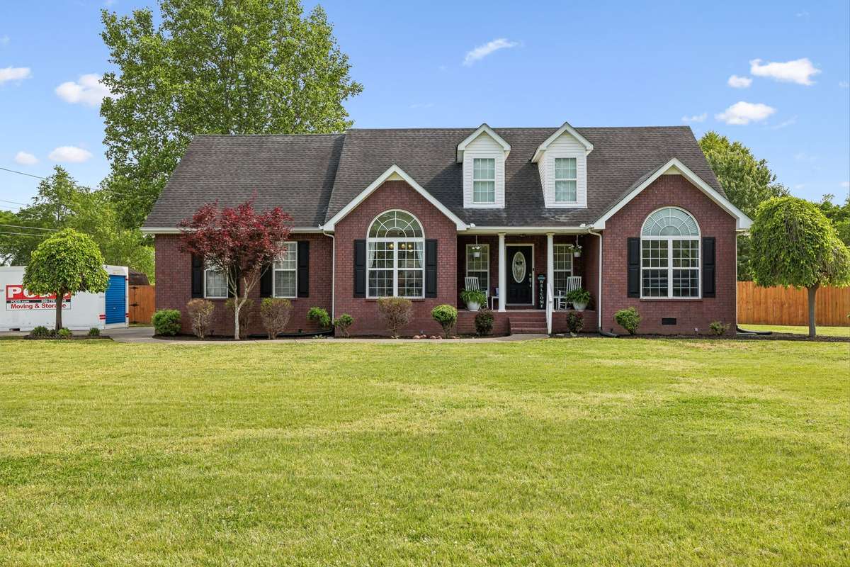 Classic brick exterior with mature trees and a peaceful Lascassas setting, with two car garage. Moving Pod in driveway.