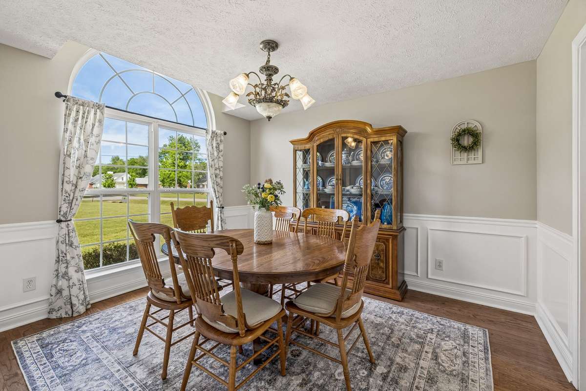 Formal dining room with arched window and classic trim details.