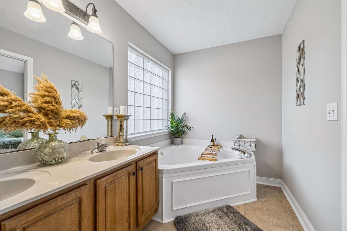 Relaxing soaking tub with glass block window for natural light.