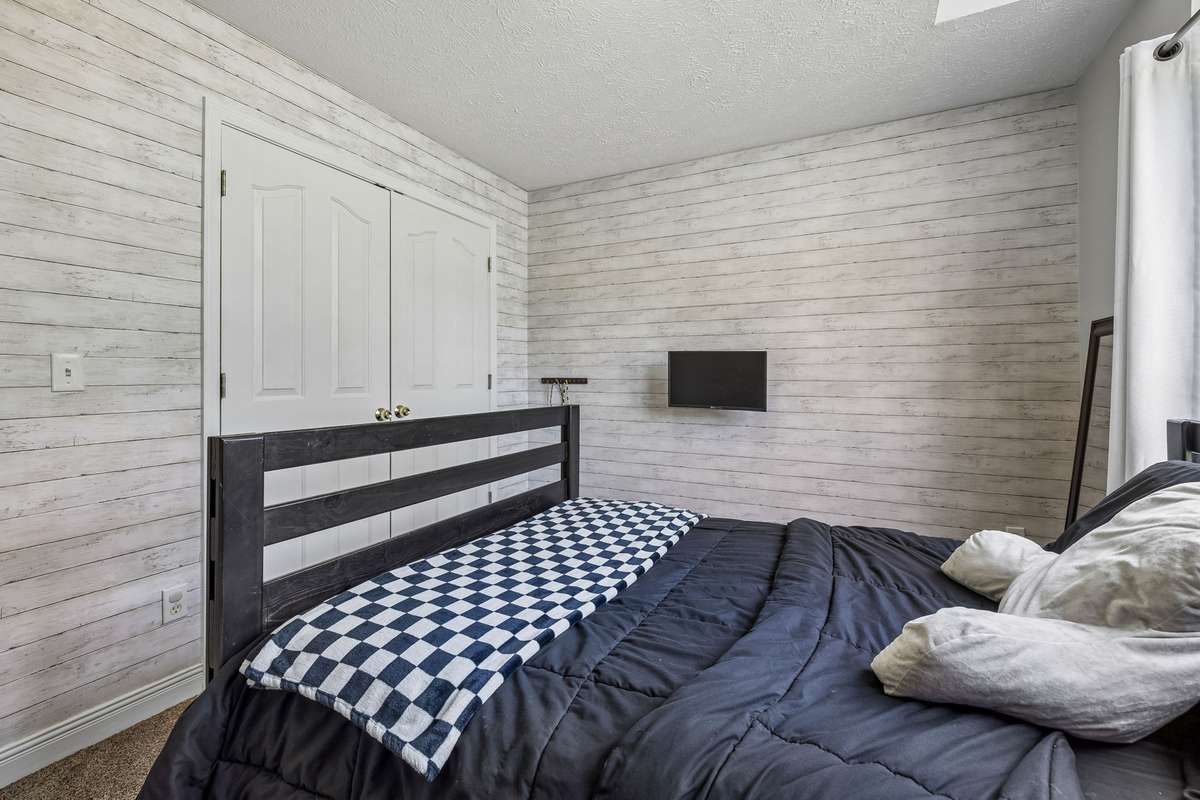 Secondary bedroom with closet and warm neutral finishes.