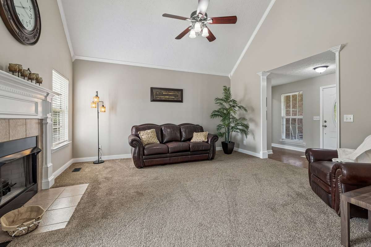 Additional living room angle with fireplace and front entry view.