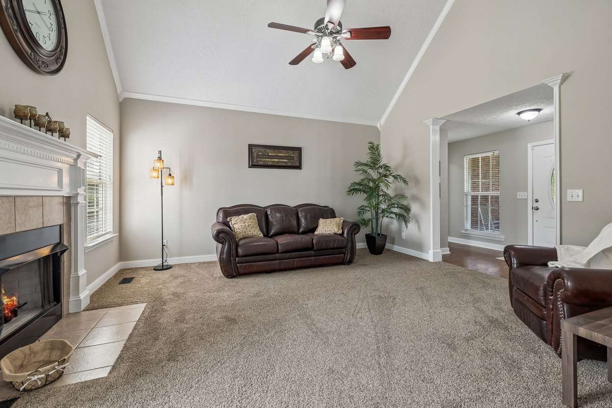 Comfortable living space with vaulted ceiling and neutral finishes.