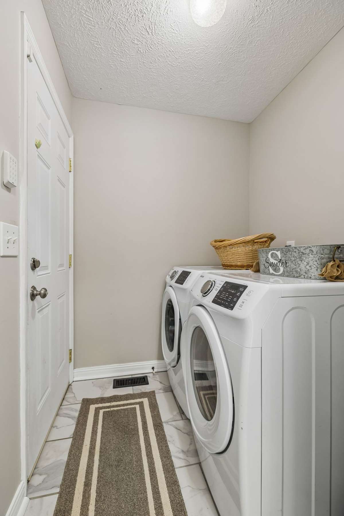 Laundry room with tile flooring and cabinet/storage potential.