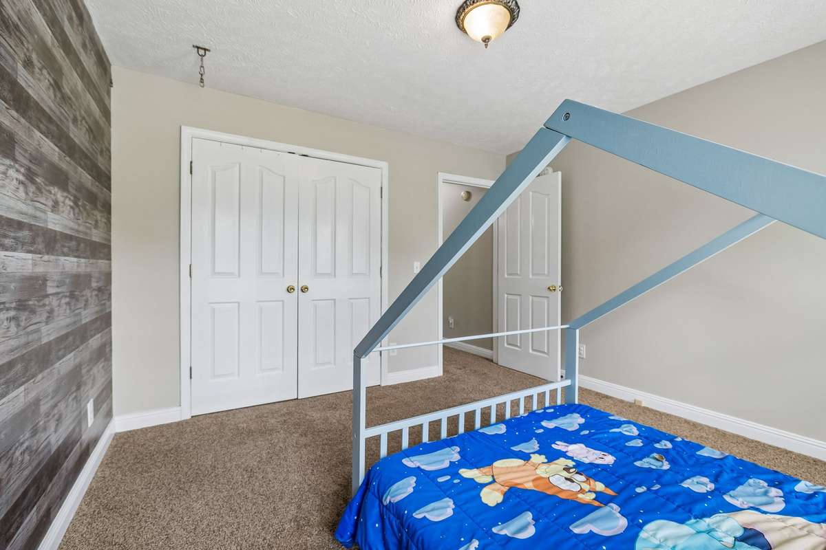 Bedroom view showing closet and neutral paint.