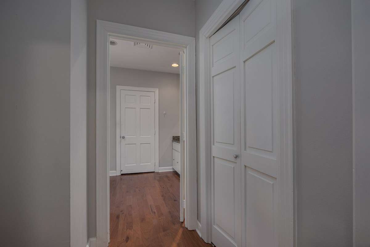 Outside of bathroom, the hallway passes a closet and heads into the bedroom area