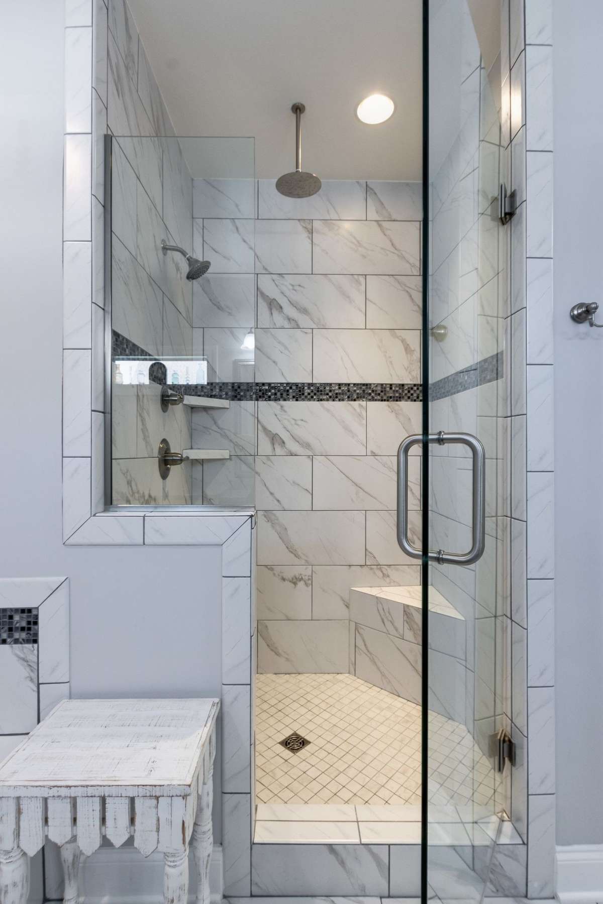 Rain shower head and corner seat in this exceptional tiled showed