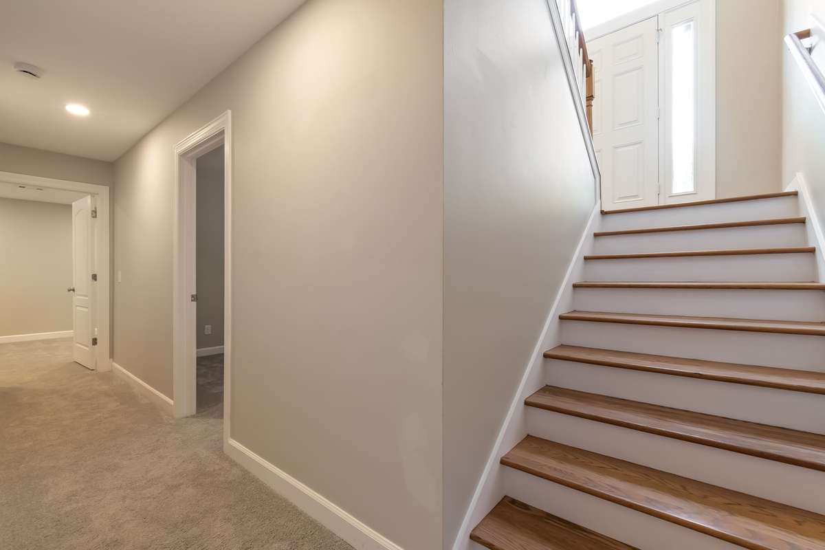 Stairs down from front door to bonus room - bedroom 5 to right